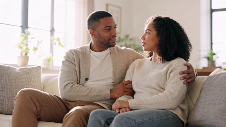 A loving couple having an intimate, supportive conversation about relationships and sexual wellness in a comfortable home setting